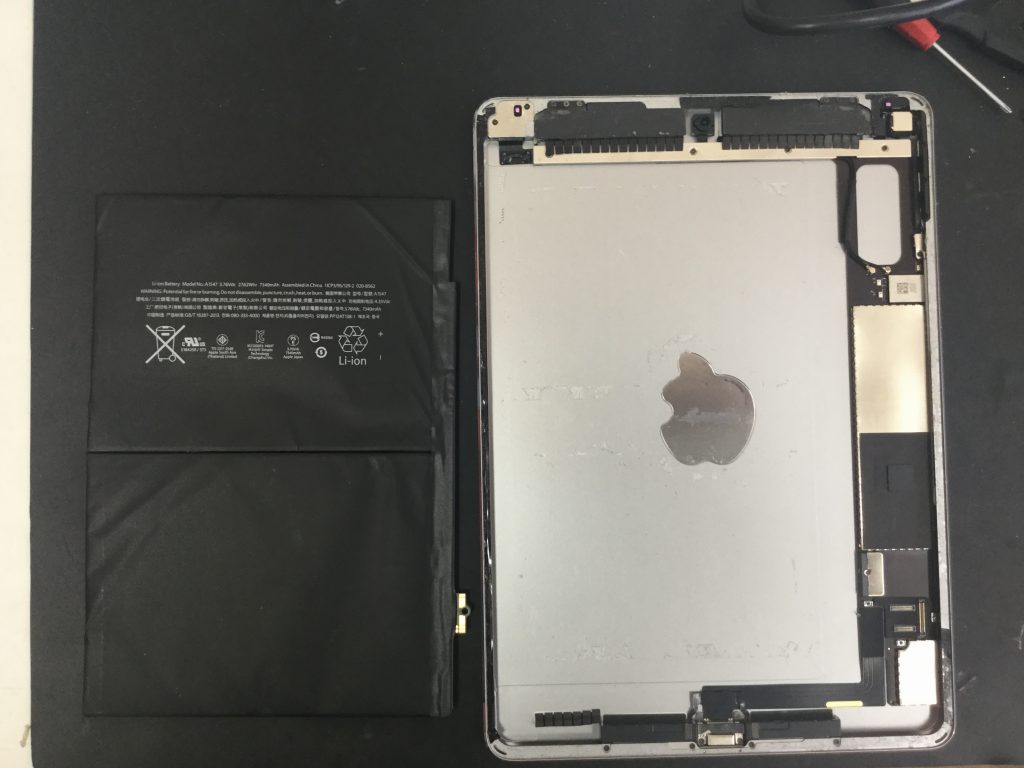 粘着テープを剥がして取り外したiPadのバッテリー